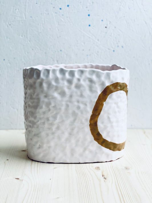 Ringlad och tummad vas. Ljust rosa med ockrafärgade cirklar.