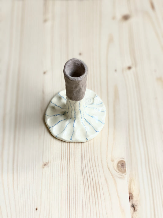 Tummad ljusstake för smalt ljus. Ljusgul med blå kritstreck.