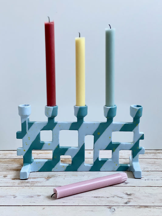 Femarmad ljusstake. Ljusblå / mörk turkos med små gula stänk.