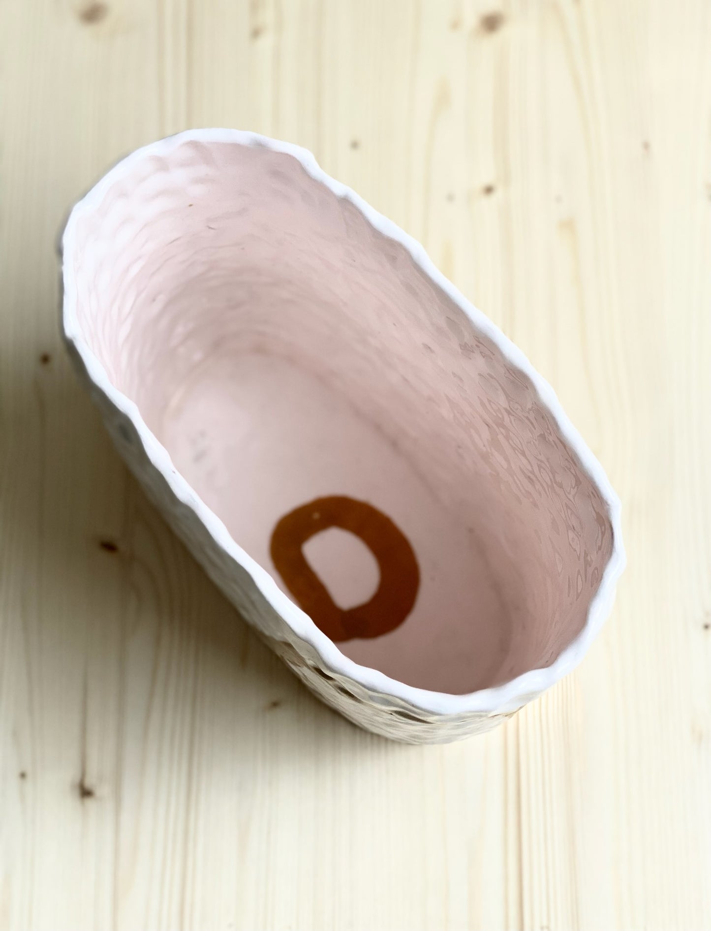 Ringlad och tummad vas. Ljust rosa med ockrafärgade cirklar.