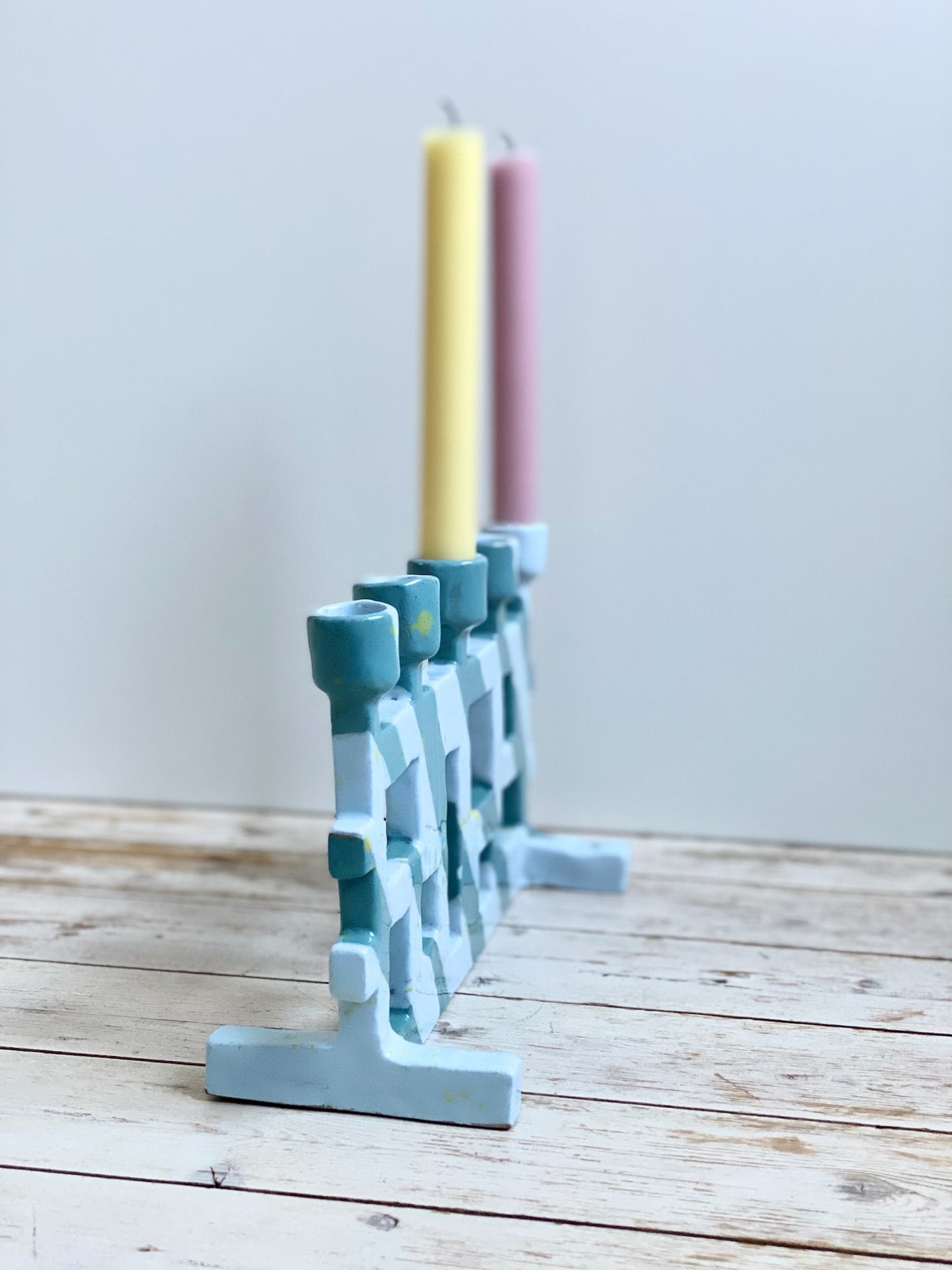 Femarmad ljusstake. Ljusblå / mörk turkos med små gula stänk.