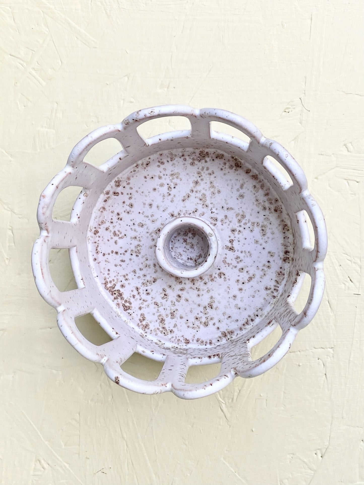 Ljusstake med bågar. Matt vit glasyr med prickar