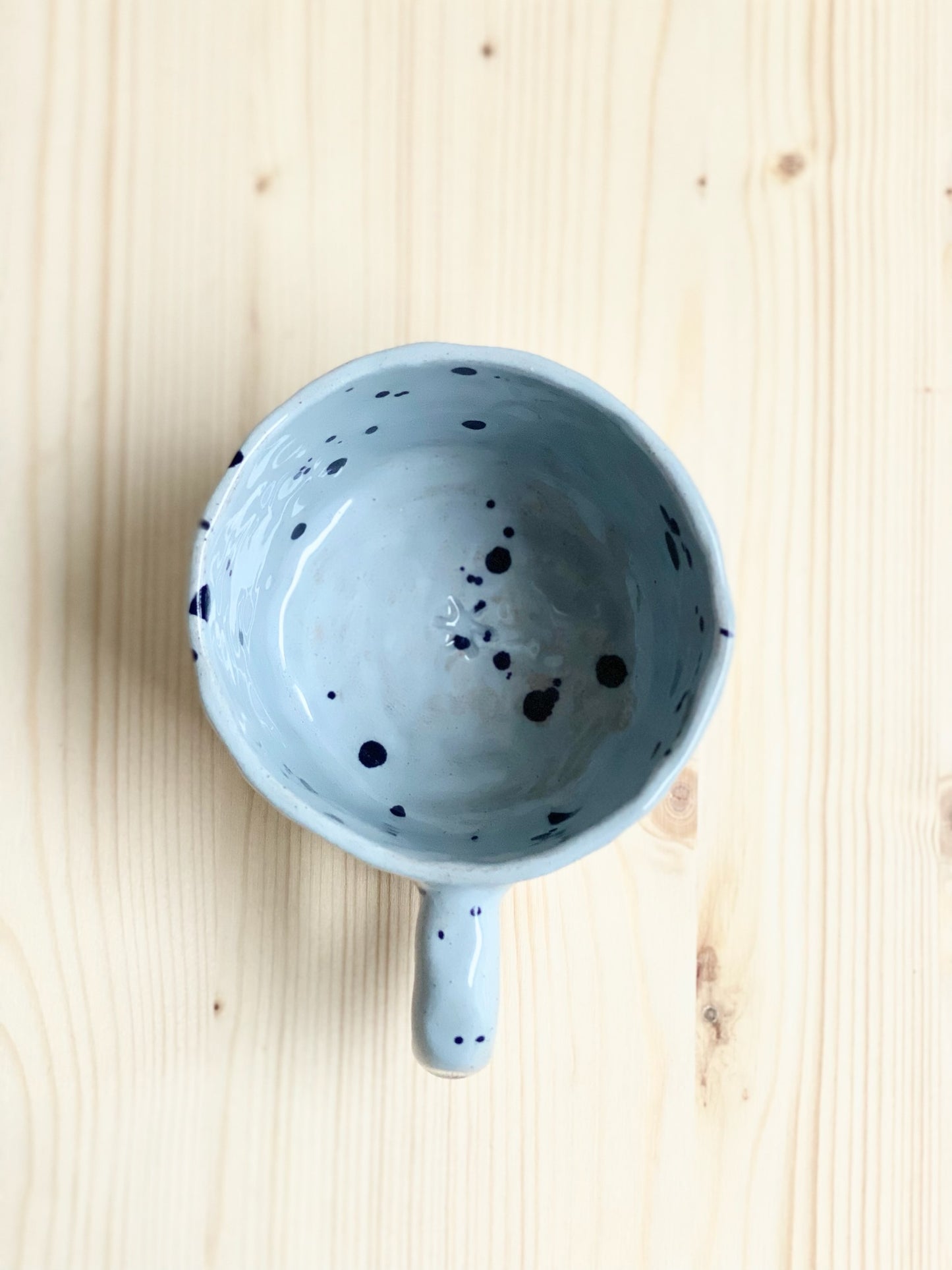 Tummad kopp.  Ljusblå med mörkare blå stänk